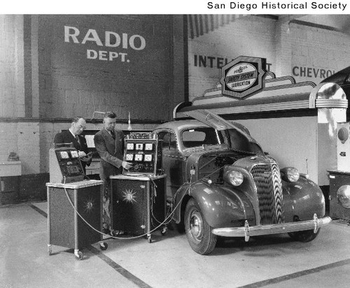 A 1937 Chevrolet being checked with diagnostic equipment used by a supervised mechanic