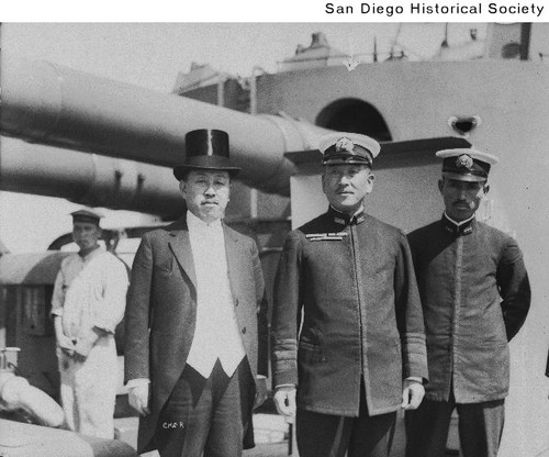 Admiral H. Saito, two sailors, and a Japanese man in formal wear aboard a warship