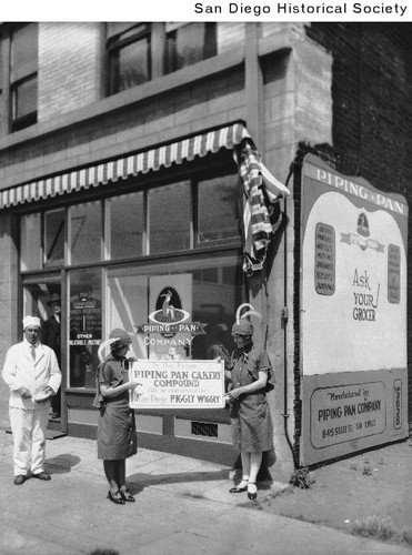 Two women in costume and a man in white advertising for the Piping Pan Cakery Company