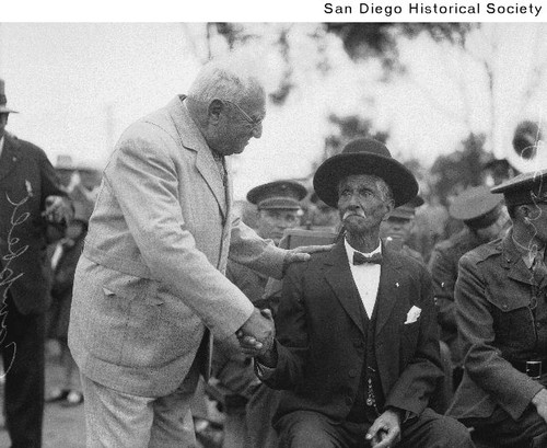 J.B. Campbell shaking hands with Louis Serrano, Sr. at an Old Town flag ceremony