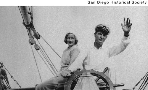 Edwin S. Larsen at the wheel of a yacht with his wife, actress Carol Dempster, seated behind him