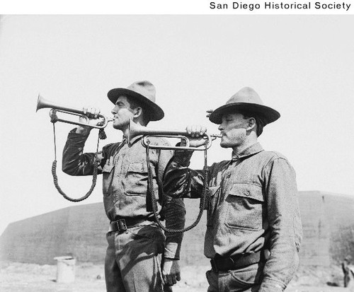 Clyde A. Cole and E.B. Scholdsack wearing U.S. Army uniforms and blowing bugles