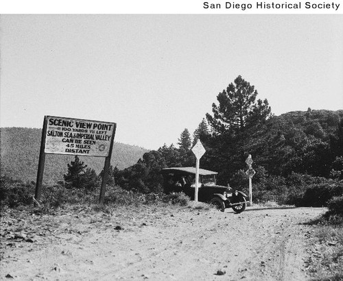 Automobile parked between two signposts at a scenic view point in the mountains east of San Diego