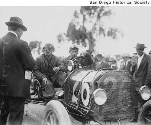 Automobile racer Earl Schnock and an unidentified rider in a racecar
