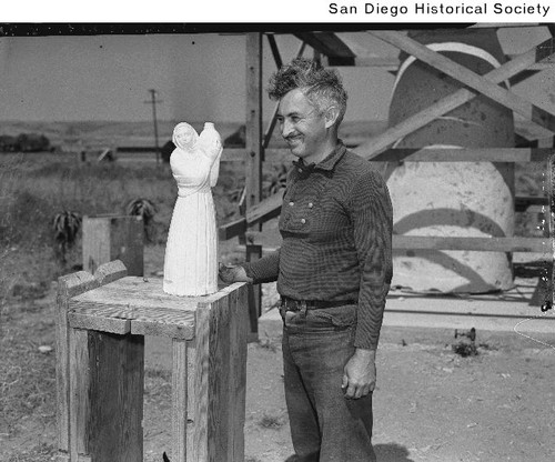 Donal Hord standing with a model of his sculpture, Guardian of the Waters