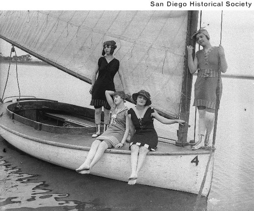 Four young women in bathing suits on a sailboat near Coronado