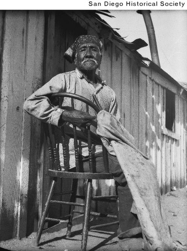 An unidentified Mesa Grande Indian man seated on a chair outside a ...