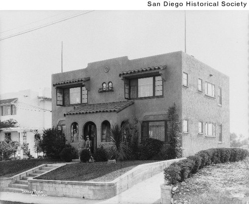 Three women standing at the porch of an apartment building