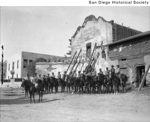 Soldiers on horseback in front of the Mission San Diego de Alcala