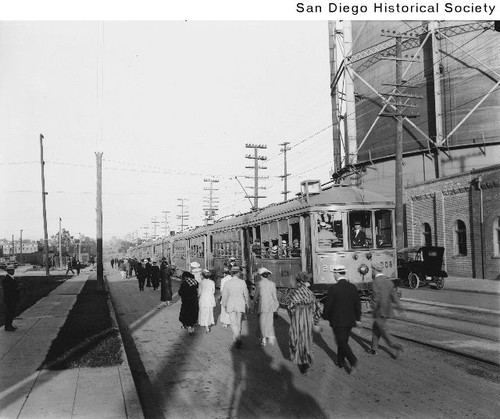 People briskly walking to catch a streetcar on a city street