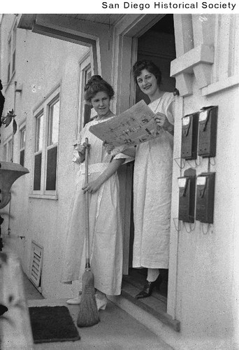 Two women standing in the doorway of an apartment house