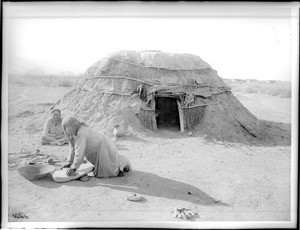 Pima Indians, Ho-Dutch and his wife, in front of their native dwelling, or "Kan", Pima, Arizona, ca.1900