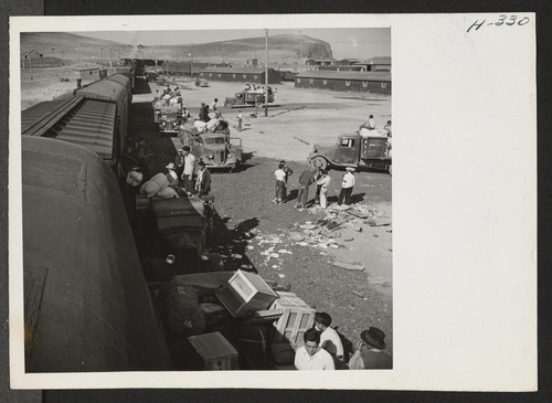 A scene at the Tule Lake freight yards, where heavy baggage belonging to the new arrivals is being transported from the baggage cars to the warehouse. Needless to say, many tons of baggage leave and arrive with each segregation train. Photographer: Mace, Charles E