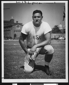 University of Southern California assistant football coach Bob Winslow, on one knee, white USC t-shirt, Bovard Field, 1946