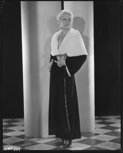 Peggy Hamilton modeling a full length velvet coat with a cape collar in fur, circa 1931-1933