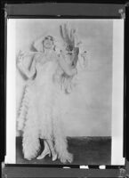 Peggy Hamilton modeling a tulle dress with matching hat and parasol, 1930