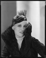 Peggy Hamilton modeling a Hortense hat and a coat with a high collar and flared cuffs, 1931