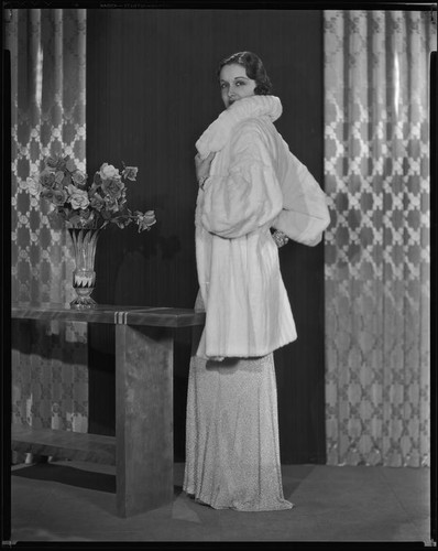 Actress Gail Patrick modeling a white Russian ermine coat, 1933
