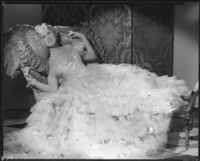 Peggy Hamilton modeling a Travis Banton gown with a full skirt of white tulle accented with gardenias, 1933