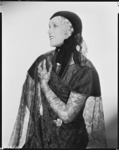 Peggy Hamilton modeling a cap with a velvet chin strap and a net veil, 1933
