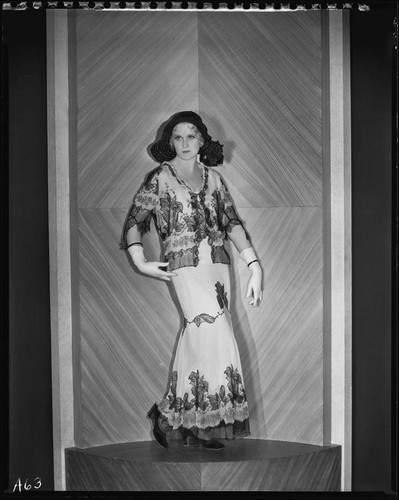 Peggy Hamilton modeling a white chiffon gown with black hand-appliqued lace, 1931