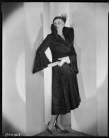 Peggy Hamilton modeling a Hortense hat and a coat with a high collar and flared cuffs, 1931