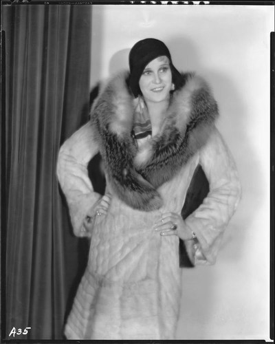 Peggy Hamilton modeling an ermine coat with red fox collar and a cloche, 1930