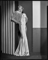 Actress Kathleen Burke modeling an evening gown with ostrich wrap, 1932