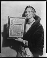 Peggy Hamilton holds plaque awarded to her by Lions Club for her service as official hostess, Los Angeles, 1932