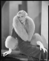 Peggy Hamilton modeling an Adrian full-length coat trimmed with fur, circa 1929-1933