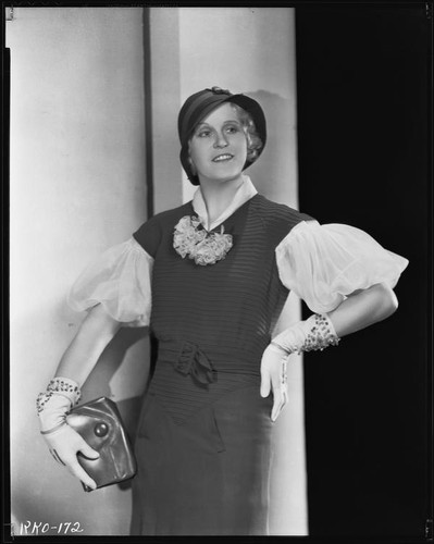 Peggy Hamilton modeling a fitted dress, a hat and embroidered gloves, circa 1931-1933