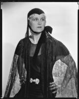 Peggy Hamilton modeling a cap with a velvet chin strap and a net veil, 1933