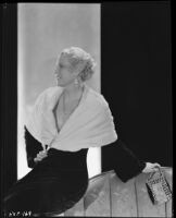 Peggy Hamilton modeling a full length velvet coat with a cape collar in fur, circa 1931-1933