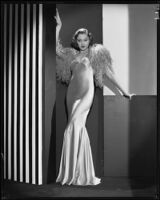 Actress Kathleen Burke modeling an evening gown with ostrich wrap, 1932