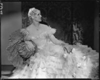 Peggy Hamilton modeling a Travis Banton gown with a full skirt of white tulle accented with gardenias, 1933