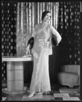 Actress Juliette Compton modeling a lace evening gown and jacket from the Walter Switzer Fashion Salon, 1932