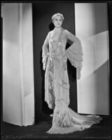 Peggy Hamilton modeling a Travis Banton hostess gown with beaded chiffon and gold lace, 1932