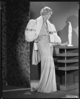 Peggy Hamilton modeling an evening gown with wide fur sleeves, 1933