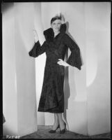 Peggy Hamilton modeling a Hortense hat and a coat with a high collar and flared cuffs, 1931