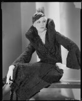 Peggy Hamilton modeling a Hortense hat and a coat with a high collar and flared cuffs, 1931