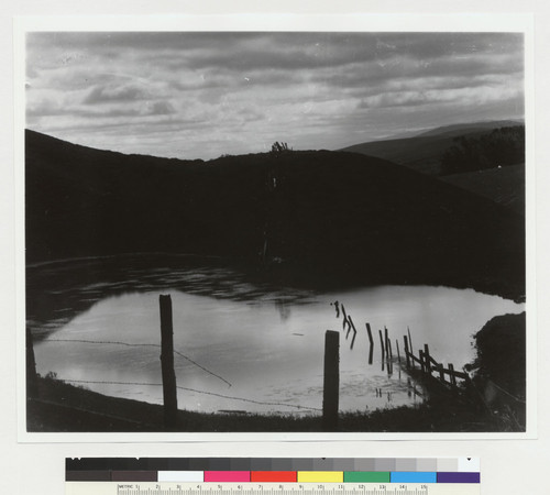 [Pond among hills with fence running through it, probably along fault line in San Mateo County.]