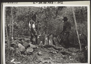 Breaking and carrying stones to rebuild the house in Kumba