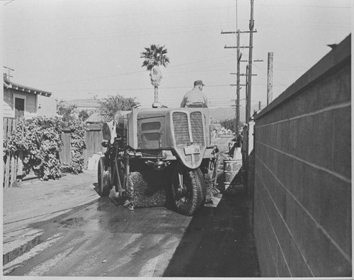 Santa Monica City Sanitation Division worker with street sweeper cleaning alley
