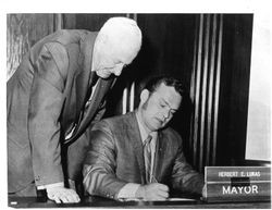 Mayor Herbert E. Lukas signing a document