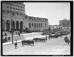 Soldiers marching in a parade in front of Los Angeles City Hall
