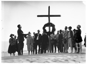 Group of people listening to a man speak at a funeral in the desert
