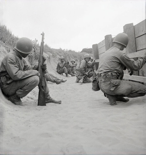 Trainees crouched behind a wall at Fort Ord
