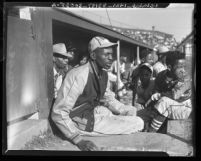 Satchel Paige with bat boys in dugout watching game in Los Angeles, Calif., circa 1943