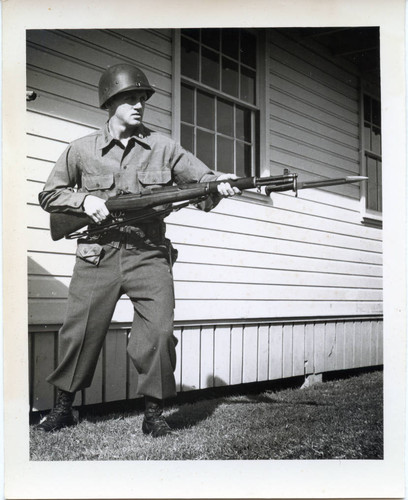 Trainee posing with rifle and bayonet at Fort Ord