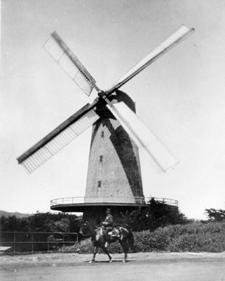 [Mounted policeman in front of windmill in Golden Gate Park]